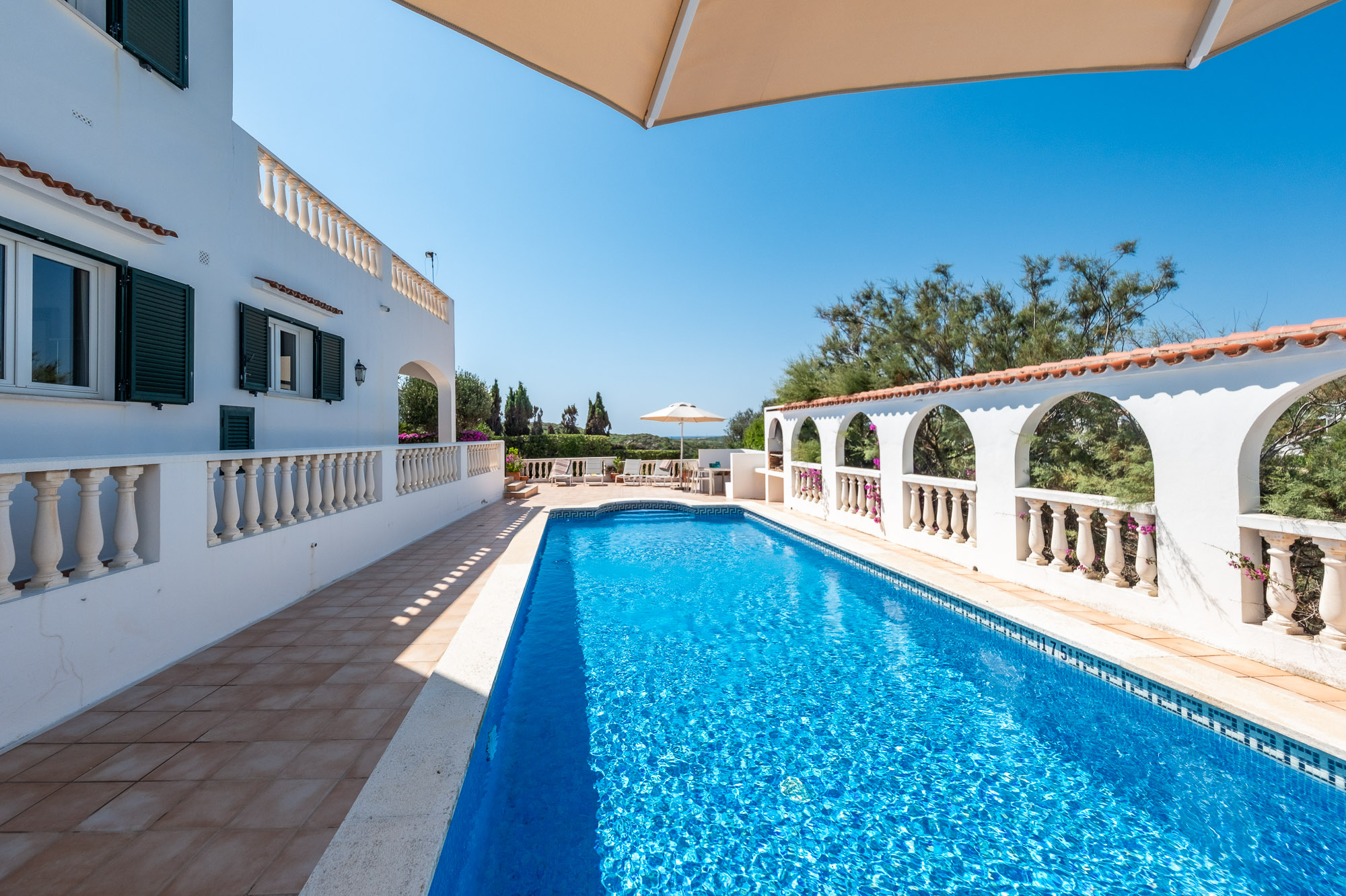 Villa sopraelevata a Cala Llonga con vista mare sul porto di Mahón e un'ampia terrazza per nuotare.